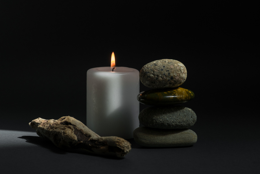 Lighted Candles and Stones on Black Background